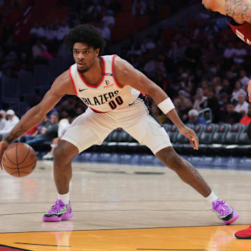 Jan 21, 2025; Miami, Florida, USA; Portland Trail Blazers guard Scoot Henderson (00) dribbles the basketball as Miami Heat center Kel'el Ware (7) defends during the third quarter at Kaseya Center. Mandatory Credit: Sam Navarro-Imagn Images