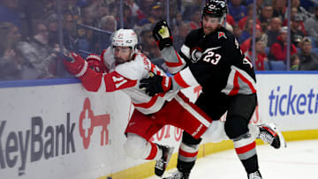 Oct 26, 2024; Buffalo, New York, USA;  Buffalo Sabres defenseman Mattias Samuelsson (23) checks Detroit Red Wings center Dylan Larkin (71) as he goes after the puck during the third period at KeyBank Center. Mandatory Credit: Timothy T. Ludwig-Imagn Images