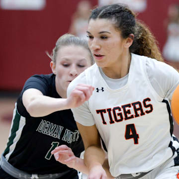 Norman's Keeley Parks, right, goes past Norman North's Kenzie Clouse during a girls high school basketball game between Norman and Norman North at Putnam City North in Oklahoma City, Okla., Tuesday, Feb. 20, 2024.