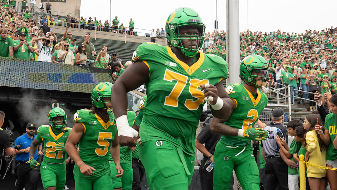 Oregon’s Emmanuel Pregnon, center, takes the field before the game against Oklahoma State at Autzen.
