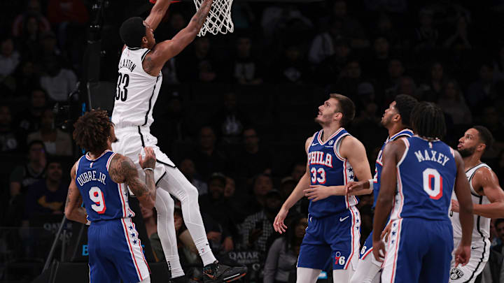 Oct 16, 2023; Brooklyn, New York, USA; Brooklyn Nets center Nic Claxton (33) dunks the ball during the first quarter in front of Philadelphia 76ers guard Kelly Oubre Jr. (9) and forward Filip Petrusev (33) at Barclays Center. Mandatory Credit: Vincent Carchietta-Imagn Images