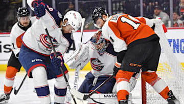 Jan 4, 2024; Philadelphia, Pennsylvania, USA; Columbus Blue Jackets defenseman Ivan Provorov (9) and goaltender Daniil Tarasov (40) battle for the puck with Philadelphia Flyers center Sean Couturier (14) during the third period at Wells Fargo Center. Mandatory Credit: Eric Hartline-Imagn Images