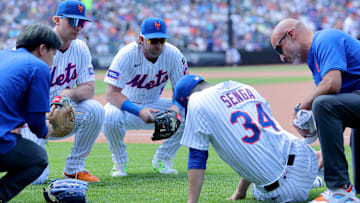 Jun 12, 2025; New York City, New York, USA; New York Mets first baseman Pete Alonso (20) and second baseman Jeff McNeil (1) watch as starting pitcher Kodai Senga (34) is tended to after sustaining an injury during the sixth inning against the Washington Nationals at Citi Field. Mandatory Credit: Brad Penner-Imagn Images