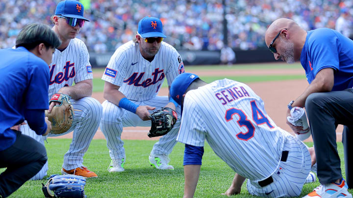 Jun 12, 2025; New York City, New York, USA; New York Mets first baseman Pete Alonso (20) and second baseman Jeff McNeil (1) watch as starting pitcher Kodai Senga (34) is tended to after sustaining an injury during the sixth inning against the Washington Nationals at Citi Field. Mandatory Credit: Brad Penner-Imagn Images