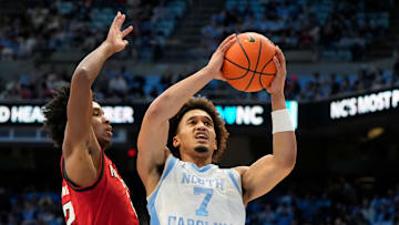 Feb 19, 2025; Chapel Hill, North Carolina, USA; North Carolina Tar Heels guard Seth Trimble (7) shoots as North Carolina State Wolfpack guard Paul McNeil (2) defends in the second half at Dean E. Smith Center. Mandatory Credit: Bob Donnan-Imagn Images