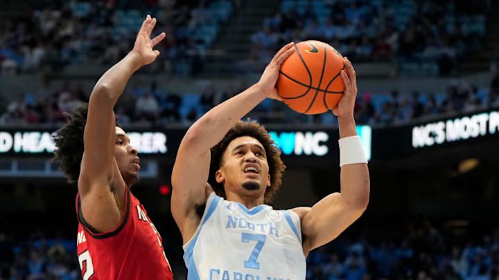 Feb 19, 2025; Chapel Hill, North Carolina, USA; North Carolina Tar Heels guard Seth Trimble (7) shoots as North Carolina State Wolfpack guard Paul McNeil (2) defends in the second half at Dean E. Smith Center. Mandatory Credit: Bob Donnan-Imagn Images