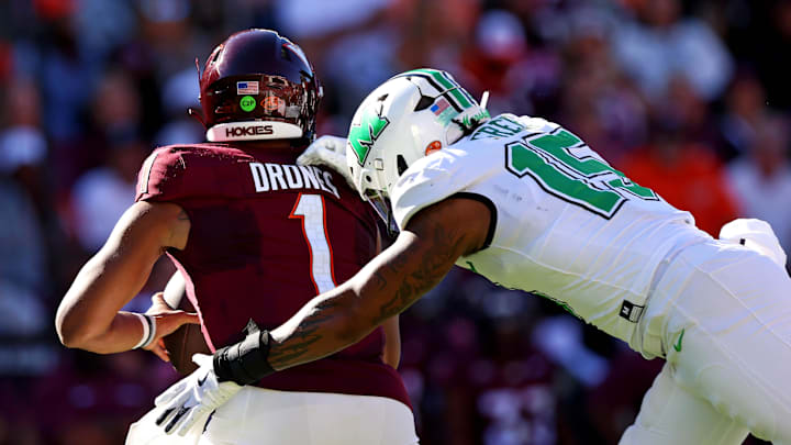 Sep 7, 2024; Blacksburg, Virginia, USA; Marshall Thundering Herd defensive lineman Mike Green (15) sacks Virginia Tech Hokies quarterback Kyron Drones (1) during the first quarter at Lane Stadium. Mandatory Credit: Peter Casey-Imagn Images