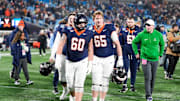 Dec 6, 2025; Charlotte, NC, USA; Virginia Cavaliers offensive lineman Drake Metcalf (60) and offensive lineman Grant Ellinger (65) waolk off the field after the game against the Duke Blue Devils during the 2025 ACC Championship game at Bank of America Stadium. Mandatory Credit: Jim Dedmon-Imagn Images