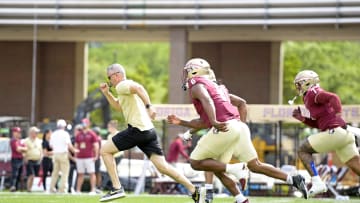 Apr 20, 2024; Tallahassee, Florida, USA; Florida State Seminoles head coach Mike Norvell races some of his players to the other end of the field during the Spring Showcase at Doak S. Campbell Stadium. Mandatory Credit: Melina Myers-USA TODAY Sports