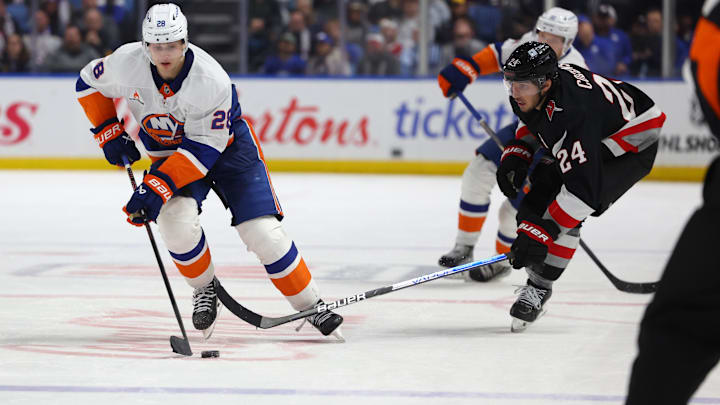 Nov 1, 2024; Buffalo, New York, USA;  New York Islanders defenseman Alexander Romanov (28) skates with the puck as Buffalo Sabres center Dylan Cozens (24) defends during the third period at KeyBank Center. Mandatory Credit: Timothy T. Ludwig-Imagn Images