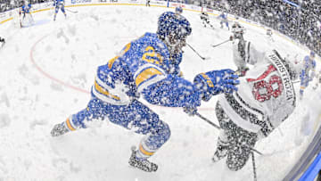 Oct 9, 2025; St. Louis, Missouri, USA; St. Louis Blues defenseman Logan Mailloux (23) skates against Minnesota Wild center Vinnie Hinostroza (18) after they sprayed ice in the air during the third period at Enterprise Center. Mandatory Credit: Jeff Curry-Imagn Images