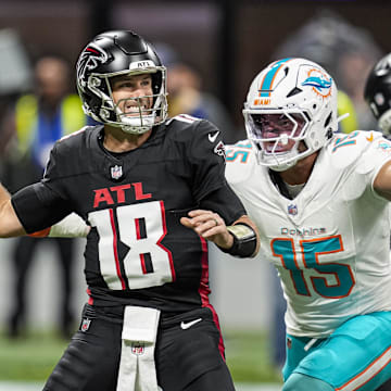 Atlanta Falcons quarterback Kirk Cousins (18) passes under pressure from Miami Dolphins linebacker Jaelan Phillips (15) during the first quarter at Mercedes-Benz Stadium.