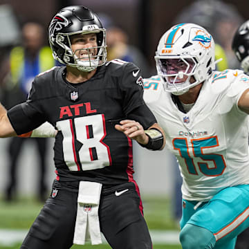 Atlanta Falcons quarterback Kirk Cousins (18) passes under pressure from Miami Dolphins linebacker Jaelan Phillips (15) during the first quarter at Mercedes-Benz Stadium.