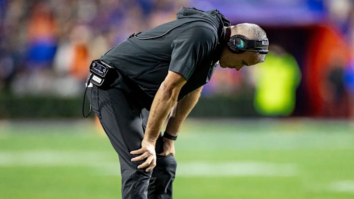 Florida State Seminoles head coach Mike Norvell holds his head between his legs during the second half against the Florida Gators at Steve Spurrier Field at Ben Hill Griffin Stadium in Gainesville, FL on Saturday, November 25, 2023. [Matt Pendleton/Gainesville Sun]