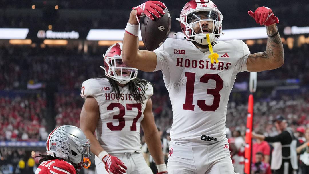 Dec 6, 2025; Indianapolis, IN, USA; Indiana Hoosiers wide receiver Elijah Sarratt (13) celebrates after scoring a touchdown against Ohio State Buckeyes cornerback Jermaine Mathews Jr. (7) in the third quarter during the 2025 Big Ten championship game at Lucas Oil Stadium. Mandatory Credit: Aaron Doster-Imagn Images