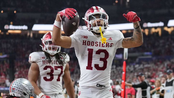 Dec 6, 2025; Indianapolis, IN, USA; Indiana Hoosiers wide receiver Elijah Sarratt (13) celebrates after scoring a touchdown against Ohio State Buckeyes cornerback Jermaine Mathews Jr. (7) in the third quarter during the 2025 Big Ten championship game at Lucas Oil Stadium. Mandatory Credit: Aaron Doster-Imagn Images