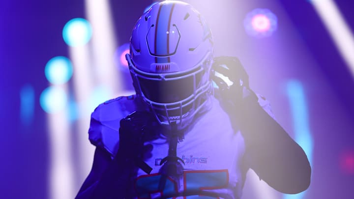 Miami Dolphins player adjusting his helmet