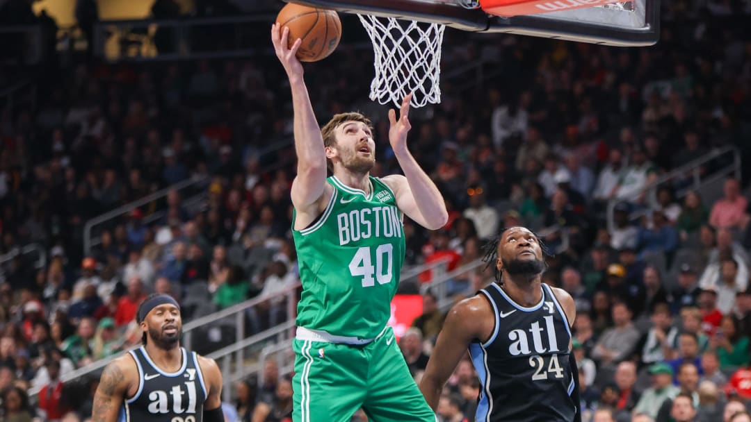 Mar 25, 2024; Atlanta, Georgia, USA; Boston Celtics center Luke Kornet (40) shoots past Atlanta Hawks guard Wesley Matthews (32) and forward Bruno Fernando (24) in the second quarter at State Farm Arena. Mandatory Credit: Brett Davis-USA TODAY Sports.