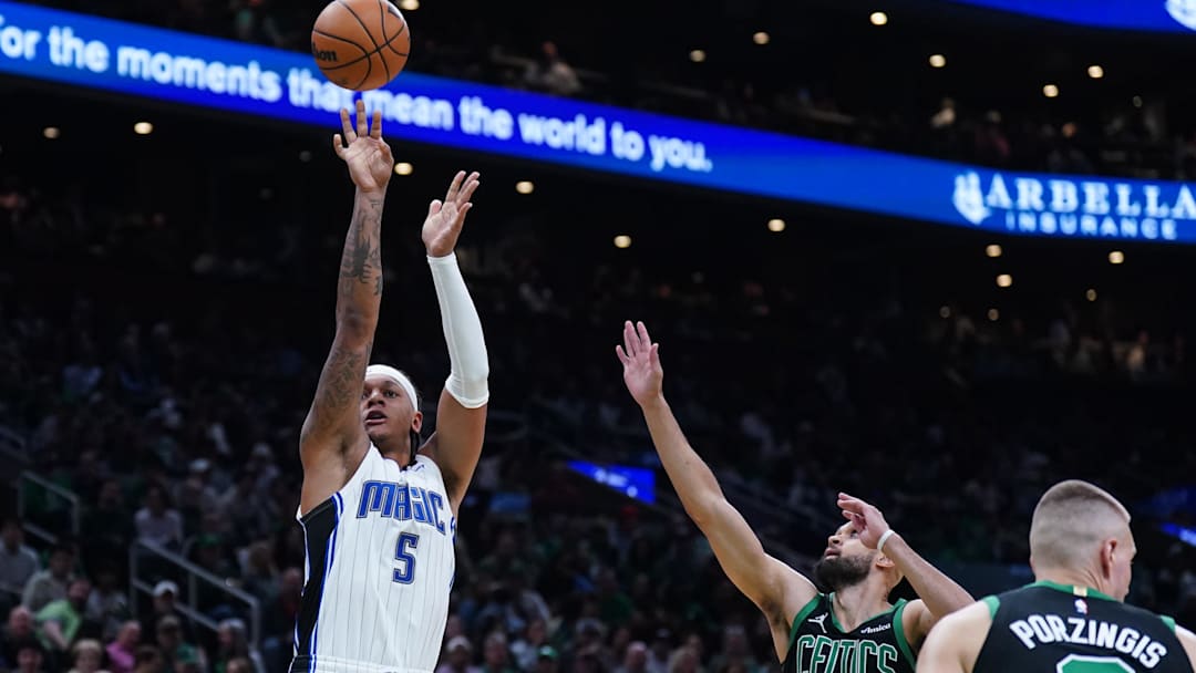 Apr 29, 2025; Boston, Massachusetts, USA; Orlando Magic forward Paolo Banchero (5) shoots the ball against Boston Celtics guard Derrick White (9) in the second quarter during game five of first round for the 2025 NBA Playoffs at TD Garden. Mandatory Credit: David Butler II-Imagn Images