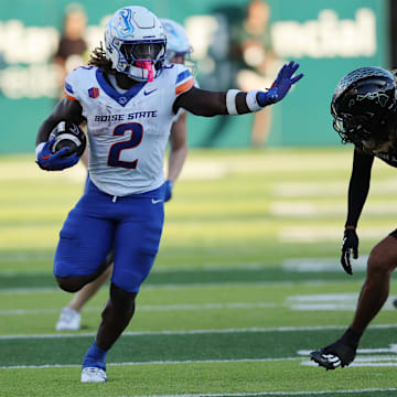 Ashton Jeanty applies the stiff arm  to Hawaii's defensive back Kilinahe Mendiola-Jensen.