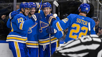 Nov 2, 2024; St. Louis, Missouri, USA;  St. Louis Blues center Jordan Kyrou (25) celebrates with center Brayden Schenn (10) center Dylan Holloway (81) and defenseman Ryan Suter (22) after scoring against the Toronto Maple Leafs during the second period at Enterprise Center. Mandatory Credit: Jeff Curry-Imagn Images