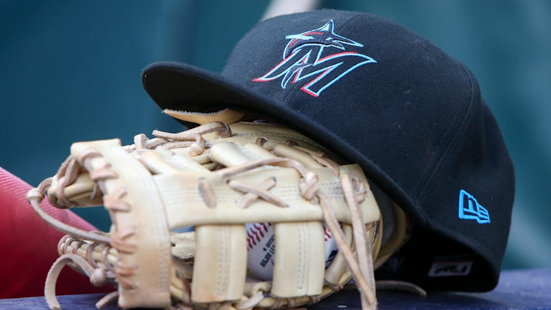 Apr 24, 2024; Atlanta, Georgia, USA; A detailed view of a Miami Marlins hat and glove in the dugout before a game against the Atlanta Braves at Truist Park. 
