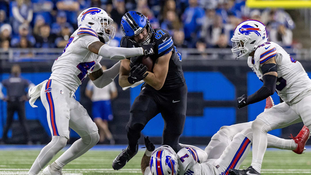 Dec 15, 2024; Detroit, Michigan, USA; Detroit Lions tight end Sam LaPorta (87) is tackled by Buffalo Bills cornerback Christian Benford (47) and cornerback Taron Johnson (7) during the second half at Ford Field. Mandatory Credit: David Reginek-Imagn Images
