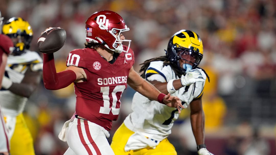 Oklahoma Sooners quarterback John Mateer (10) throws as Michigan Wolverines linebacker Jaishawn Barham (1) chases 