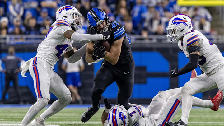 Dec 15, 2024; Detroit, Michigan, USA; Detroit Lions tight end Sam LaPorta (87) is tackled by Buffalo Bills cornerback Christian Benford (47) and cornerback Taron Johnson (7) during the second half at Ford Field. Mandatory Credit: David Reginek-Imagn Images