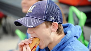 Milwaukee Brewers fan Adam Wojciechowski, 16, eats a hot dog while tailgating at Miller Park. 