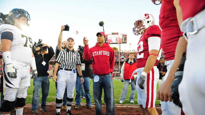 November 21, 2009; Stanford, CA, USA; Professional golfer Tiger Woods (center) flips a coin during the coin toss before the game between the California Golden Bears and the Stanford Cardinal at Stanford Stadium. The Golden Bears defeated the Cardinal 34-28. Mandatory Credit: Kyle Terada-USA TODAY Sports