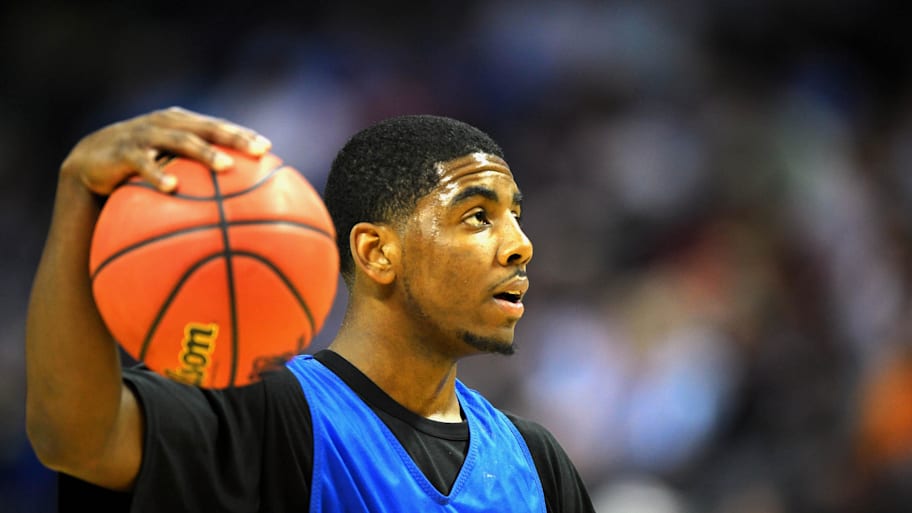 Kyrie Irving holds a basketball.