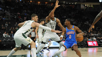 Oct 10, 2021; Milwaukee, Wisconsin, USA;  Oklahoma City Thunder guard Shai Gilgeous-Alexander (2) drives into the paint against Milwaukee Bucks center Brook Lopez (11) and Milwaukee Bucks forward Giannis Antetokounmpo (34) in the first half at Fiserv Forum. Mandatory Credit: Michael McLoone-USA TODAY Sports