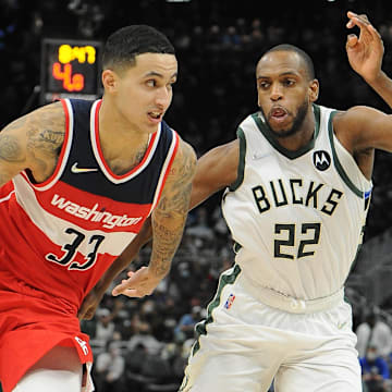 Kyle Kuzma drives to the basket while being guarded by Khris Middleton during a game in February 2022.