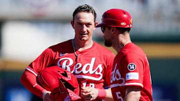 Cincinnati Reds outfielder Austin Hays speaks with first base coach Collin Cowgill in the first inning of a Cactus League game between the Cincinnati Reds and Cleveland Guardians