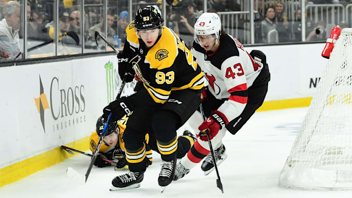 Apr 15, 2025; Boston, Massachusetts, USA; Boston Bruins center Fraser Minten (93) controls the puck while New Jersey Devils defenseman Luke Hughes (43) defends during the third period at TD Garden. Mandatory Credit: Bob DeChiara-Imagn Images