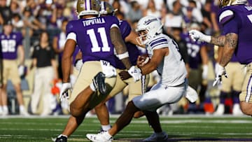 Sep 21, 2024; Seattle, Washington, USA; Northwestern Wildcats quarterback Jack Lausch (12) rushes against the Washington Huskies during the second quarter at Alaska Airlines Field at Husky Stadium. Mandatory Credit: Joe Nicholson-Imagn Images