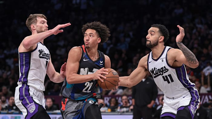 Apr 7, 2024; Brooklyn, New York, USA; Brooklyn Nets forward Jalen Wilson (22) looks to pass as Sacramento Kings center Domantas Sabonis (10) and forward Trey Lyles (41) defend him. 