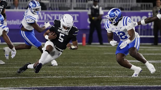  Duke Blue Devils linebacker Tre Freeman (12) tries to tackle Northwestern Wildcats quarterback Mike Wright (5) during the fi