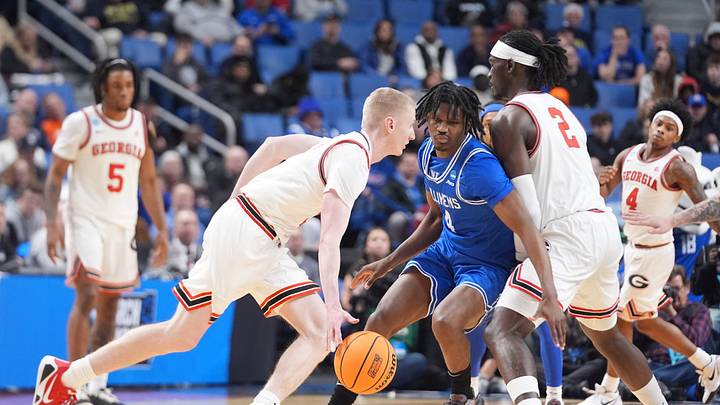 Mar 19, 2026; Buffalo, NY, USA; Georgia Bulldogs guard Blue Cain (0) drives to the basket against Saint Louis Billikens guard Amari McCottry (4) during the first half of a first round game of the men's 2026 NCAA Tournament at Keybank Center. Mandatory Credit: Gregory Fisher-Imagn Images