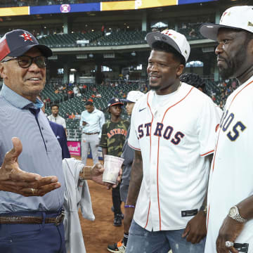 Jul 30, 2024; Houston, Texas, USA; Reggie Jackson (left) talks with Andre Johnson (middle) and rapper 50 Cent (right).