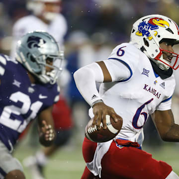 Nov 26, 2022; Manhattan, Kansas, USA; Kansas Jayhawks quarterback Jalon Daniels (6) runs away from Kansas State Wildcats safety Drake Cheatum (21) during the fourth quarter at Bill Snyder Family Football Stadium.