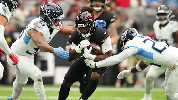 Arizona Cardinals running back Michael Carter splits Tennessee Titans defenders Cedric Gray and Xavier Woods