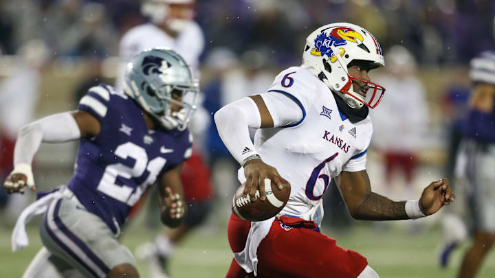 Nov 26, 2022; Manhattan, Kansas, USA; Kansas Jayhawks quarterback Jalon Daniels (6) runs away from Kansas State Wildcats safety Drake Cheatum (21) during the fourth quarter at Bill Snyder Family Football Stadium.