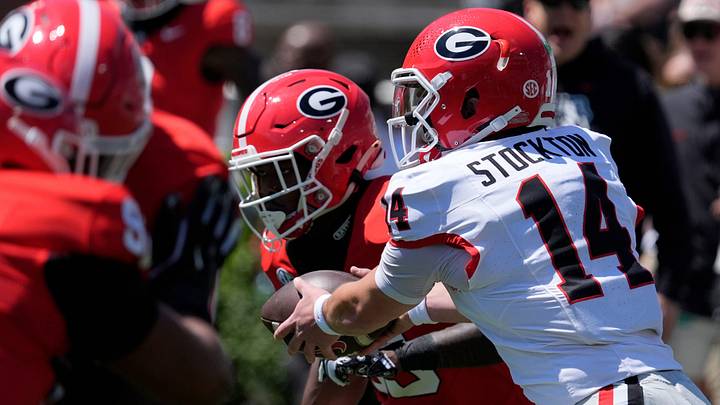 Georgia quarterback Gunner Stockton (14) hands off the ball to Georgia running back Nate Frazier (3) 
