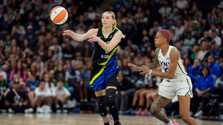 Dallas Wings guard Paige Bueckers passes by the defense of Minnesota Lynx guard Courtney Williams.