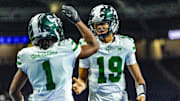 Detroit Cass Tech QB Donald Tabron II (19) celebrates Corey Sadler Jr.’s (1) touchdown against Hudsonville in the second quarter during the MHSAA Division 1 football finals at Ford Field in Detroit on Saturday, Nov. 30, 2024.