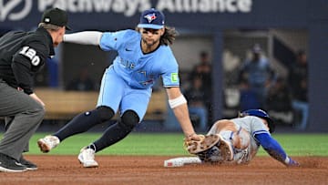 Apr 30, 2024; Toronto, Ontario, CAN;   Toronto Blue Jays shortstop Bo Bichette (11) tags out Kansas City Royals shortstop Bobby Witt Jr. (7) on an attempted steal in the sixth inning at Rogers Centre. Mandatory Credit: Dan Hamilton-Imagn Images