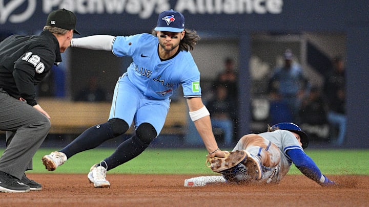 Apr 30, 2024; Toronto, Ontario, CAN;   Toronto Blue Jays shortstop Bo Bichette (11) tags out Kansas City Royals shortstop Bobby Witt Jr. (7) on an attempted steal in the sixth inning at Rogers Centre. Mandatory Credit: Dan Hamilton-Imagn Images