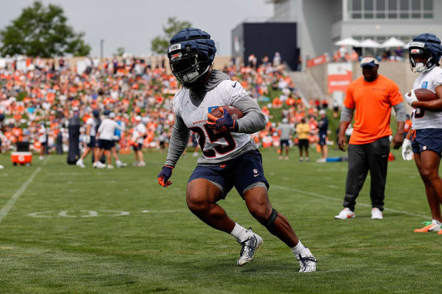 Running back carries football in practice.